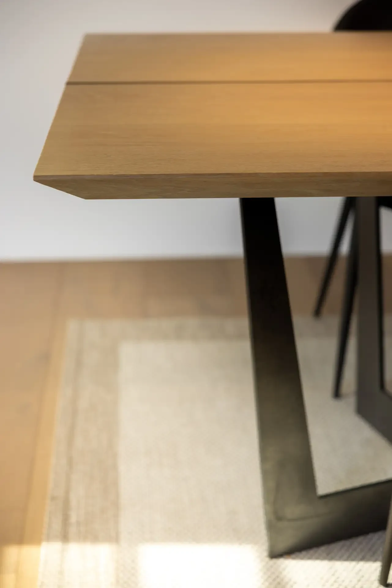 Timber table edge meeting a woven rug